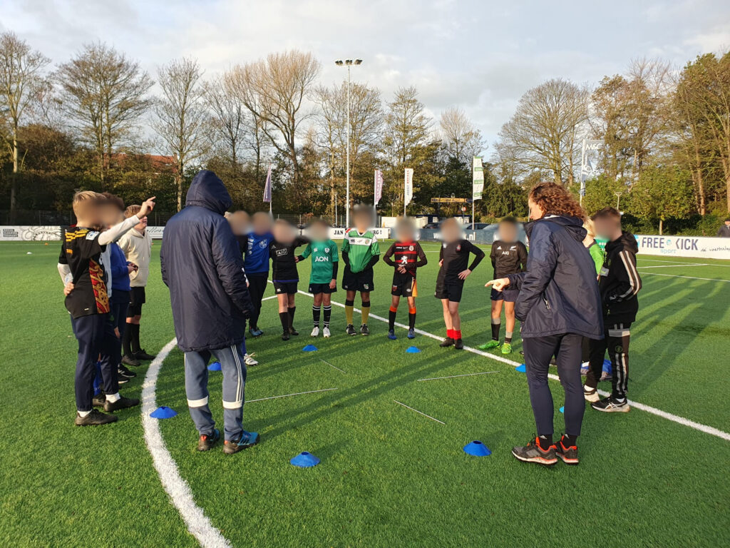 Jonge sporters op het rugby veld aan het oefenen met mentale training samen met Petra
